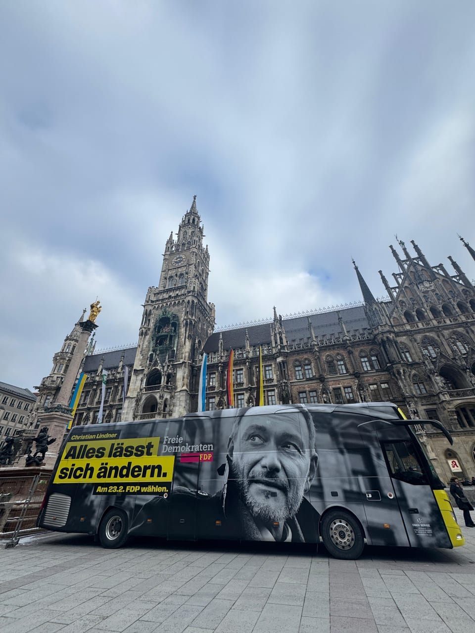 Der FDP-Wahlkampfbus mit einem großen Schwarz-Weiß-Porträt von Christian Lindner und dem Slogan „Alles lässt sich ändern. Am 23.2. FDP wählen.“ auf dem Münchner Marienplatz vor dem Neuen Rathaus
