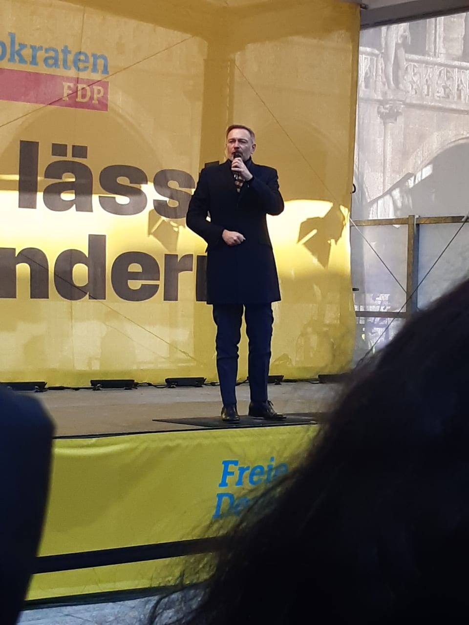 Christian Lindner spricht in ein Mikrofon auf der Bühne vor einer großen gelben FDP-Wand mit dem Schriftzug „Alles lässt sich ändern“