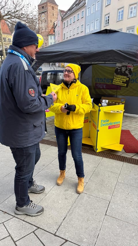 Ulla Schäfer im Gespräch mit einem Stadtratskollegen vor dem FDP-Stand, im Hintergrund der Landsberger Schmalzturm