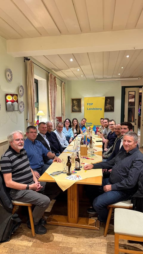 Mitglieder des FDP-Kreisverbands an einer langen Tafel in einem Gasthaus, im Hintergrund ein FDP-Landsberg-Rollup