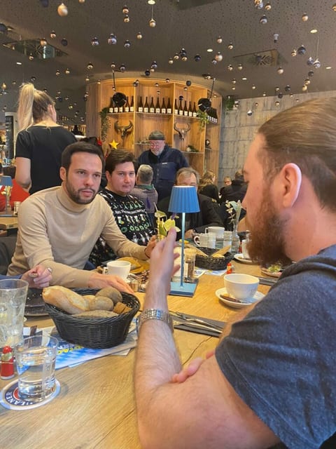 Gäste im Gespräch am Frühstückstisch eines weihnachtlich dekorierten Cafés