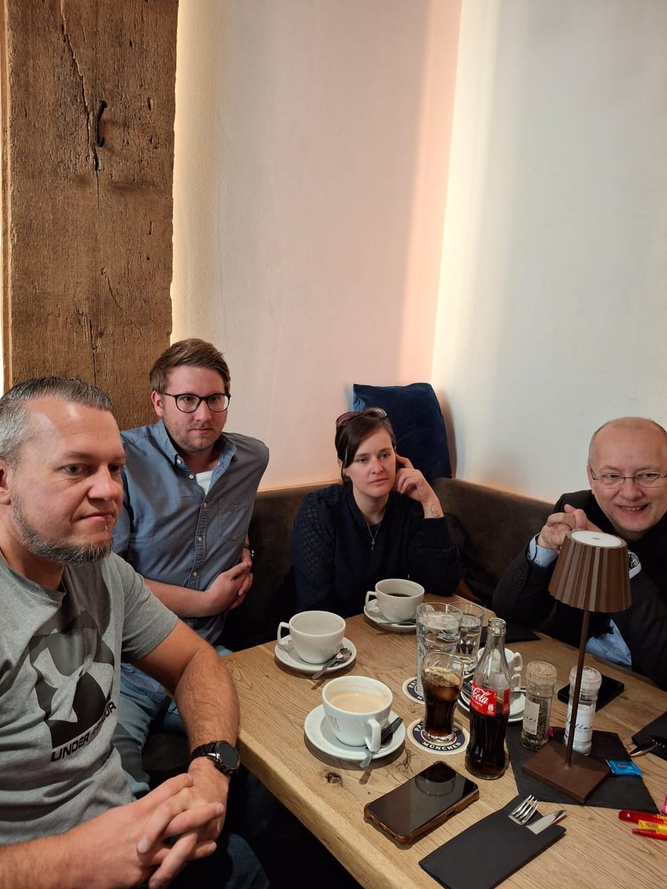 Vier Gäste, darunter Parteifreunde aus dem FDP Unterallgäu, sitzen an der Ecke eines Tisches bei Kaffee, Wasser und Cola