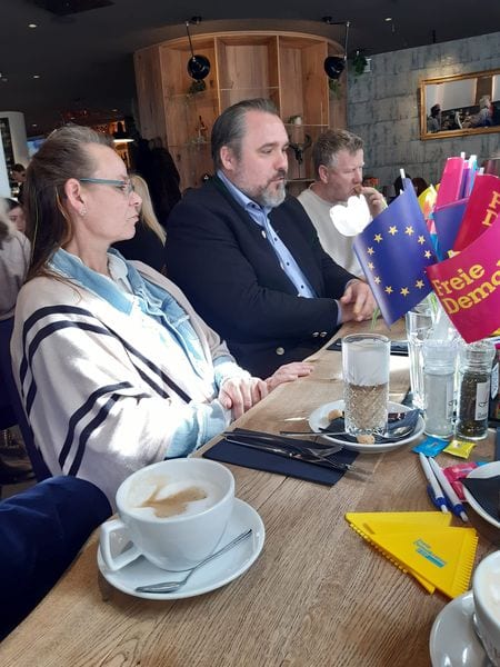 Gäste am Frühstückstisch mit FDP- und Europafahnen als Tischfähnchen und Kaffeetassen